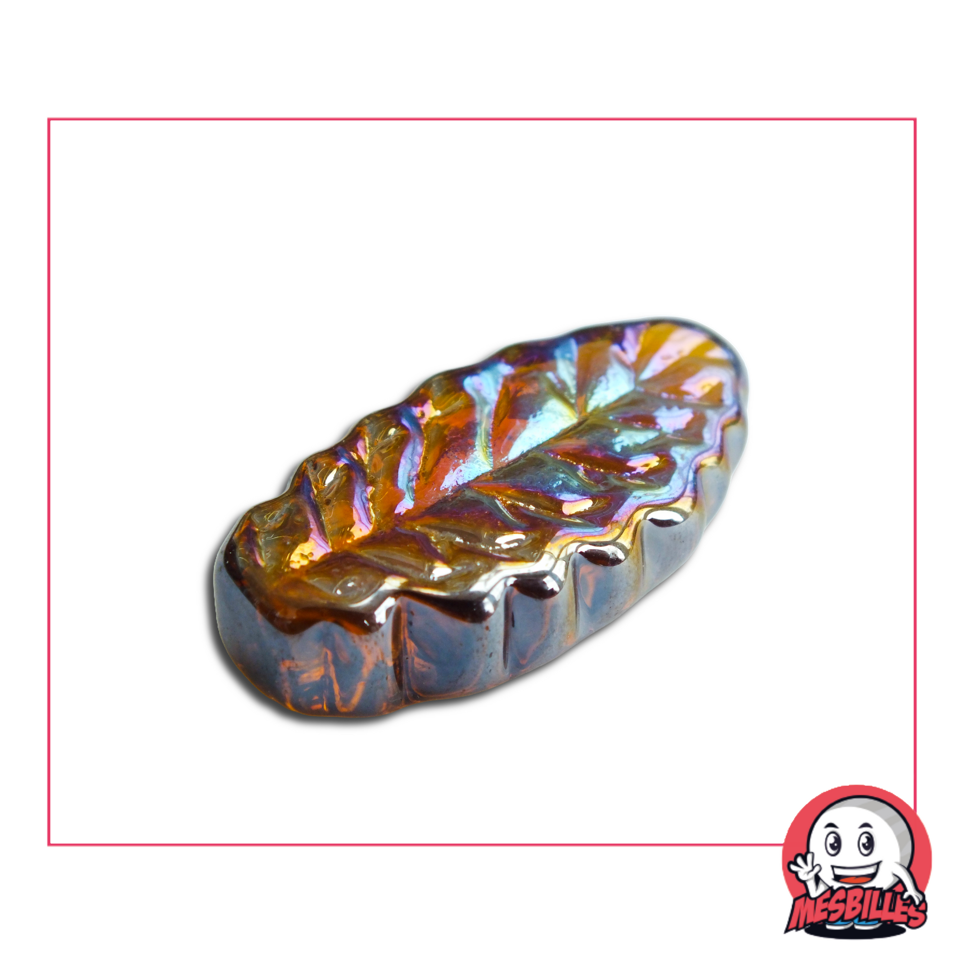 Photo d’une bille plate en forme de feuille de frêne, en verre ambre irisé de 4 cm, vendue à l’unité sur la boutique MesBilles.
